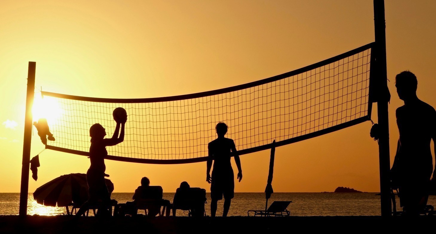 People playing volleyball in the sunset